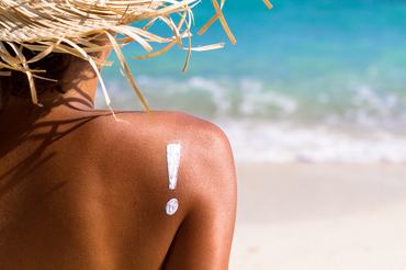 young woman on beach with suntan lotion